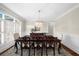 Dining room features large window with shutters and chandelier with dark-stained wooden table at 6252 Fernstone Trl, Acworth, GA 30101