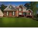 A classic red brick home with black shutters, a manicured lawn, and mature trees at 6252 Fernstone Trl, Acworth, GA 30101