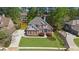 Aerial view showcasing the home's brick exterior, landscaping, and extended driveway at 6252 Fernstone Trl, Acworth, GA 30101