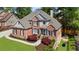 Beautifully designed home featuring a brick facade, lush landscaping, and mature trees at 6252 Fernstone Trl, Acworth, GA 30101