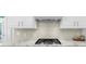 Well-equipped kitchen features a sleek gas cooktop and stylish backsplash at 6252 Fernstone Trl, Acworth, GA 30101