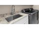 Laundry room features a stainless steel sink, granite countertops and modern washer/dryer at 6252 Fernstone Trl, Acworth, GA 30101