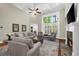 Bright living room featuring a fireplace, high ceilings, a ceiling fan, and large windows at 6252 Fernstone Trl, Acworth, GA 30101