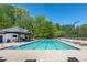 Community pool with surrounding lounge chairs, picnic area, and tennis court in the background at 2361 Maplewood Ct # 25, Atlanta, GA 30339