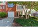 Charming townhouse featuring a one car garage, brick facade, manicured landscaping, and inviting entrance at 2361 Maplewood Ct # 25, Atlanta, GA 30339