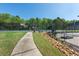 View of the community tennis court with green fencing, landscaping, and nearby walking path at 2361 Maplewood Ct # 25, Atlanta, GA 30339
