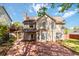 Spacious backyard featuring a large brick patio and a covered porch area at 2470 Suwanee Lakes Trl, Suwanee, GA 30024