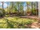 Lush backyard featuring a combination of green grass, trees and a brick patio at 2470 Suwanee Lakes Trl, Suwanee, GA 30024