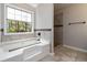 Bright bathroom features a soaking tub with tile surround and a tiled shower at 2470 Suwanee Lakes Trl, Suwanee, GA 30024