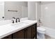 Bathroom featuring dark wood vanity, quartz countertop, and shower with glass door at 2470 Suwanee Lakes Trl, Suwanee, GA 30024