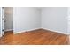 Bedroom with hardwood floors and neutral paint with closet and door to hall at 2470 Suwanee Lakes Trl, Suwanee, GA 30024