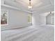 Spacious bedroom featuring tray ceiling, neutral carpet and multiple windows at 2470 Suwanee Lakes Trl, Suwanee, GA 30024