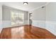Formal dining room featuring hardwood floors, wainscoting, and a large window, creating an elegant space at 2470 Suwanee Lakes Trl, Suwanee, GA 30024