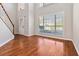 Sunlit living room with hardwood floors, large windows, and a spacious layout, perfect for entertaining at 2470 Suwanee Lakes Trl, Suwanee, GA 30024