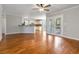 Open-concept living room features hardwood floors, ceiling fan, and access to the kitchen and outdoor space at 2470 Suwanee Lakes Trl, Suwanee, GA 30024