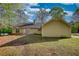 Backyard of the home with a patio and a lush lawn, surrounded by mature trees at 260 Eastwood Forest, Covington, GA 30014