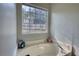 Bathroom featuring a soaking tub, a window offering outdoor views, and neutral wall paint at 260 Eastwood Forest, Covington, GA 30014