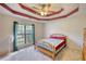 Cozy bedroom featuring a wooden bed frame, neutral carpet, and a large window overlooking outdoor scenery at 260 Eastwood Forest, Covington, GA 30014