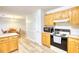 Traditional kitchen featuring wooden cabinets, white appliances, and open access to the dining area at 260 Eastwood Forest, Covington, GA 30014