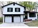 Charming two-story home boasts a white exterior with black accents and a two-car garage at 3867 Cherie Glen Rd, Snellville, GA 30039
