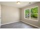 Bedroom showcasing natural light from the window, neutral walls and gray flooring at 960 Revere Way, Hampton, GA 30228