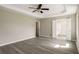 This empty bedroom features an open door, ceiling fan, and hard-surface flooring at 960 Revere Way, Hampton, GA 30228