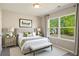 This staged bedroom features a large window, neutral tones, and updated fixtures at 960 Revere Way, Hampton, GA 30228