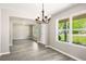 Dining room featuring hardwood floors, modern lighting, and lots of windows with a view to the front yard at 960 Revere Way, Hampton, GA 30228