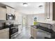 Bright kitchen featuring stainless steel appliances, granite countertops, neutral-colored cabinets, and new hardwood floors at 960 Revere Way, Hampton, GA 30228