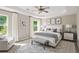 This staged main bedroom features a ceiling fan, tray ceiling, and large rug at 960 Revere Way, Hampton, GA 30228