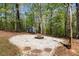 Backyard fire pit area with shed surrounded by mature trees, ideal for relaxation at 11268 Flat Shoals Rd, Covington, GA 30016