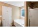 Bright bathroom showcases a soaking tub, a separate shower, and neutral color palette at 11268 Flat Shoals Rd, Covington, GA 30016