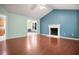 Cozy living room featuring hardwood floors, vaulted ceiling, and white-mantled fireplace at 11268 Flat Shoals Rd, Covington, GA 30016