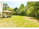 Large backyard with lush lawn, mature trees, and a gazebo at 2365 Oakland Trail Way, Lawrenceville, GA 30044