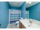 Bathroom with blue painted walls, single sink vanity, tile floor, and shower with curtain at 2365 Oakland Trail Way, Lawrenceville, GA 30044