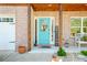 Charming front porch with brickwork, a welcoming turquoise door, and a 'WELCOME' sign at 2365 Oakland Trail Way, Lawrenceville, GA 30044