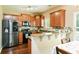 Open kitchen with stainless steel appliances, wood cabinets, granite counters, and an adjacent eat-in area at 2365 Oakland Trail Way, Lawrenceville, GA 30044