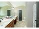 Main bathroom with double sinks, neutral color scheme, and a tile floor at 2365 Oakland Trail Way, Lawrenceville, GA 30044