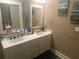 Well-lit bathroom featuring double sinks, white cabinets, and decorative mirrors and art at 278 Mission Oak Se Dr, Grayson, GA 30017