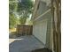 Attached two-car garage with white door and light gray siding and a wood fence at 278 Mission Oak Se Dr, Grayson, GA 30017