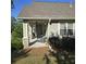 Inviting covered porch with stone pillars, ceiling fan, and comfortable seating area for outdoor relaxation at 278 Mission Oak Se Dr, Grayson, GA 30017