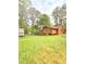 Backyard of the house with some trees and foliage. Grass is overgrown and unkempt at 1445 Diplomat Dr, Riverdale, GA 30296