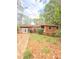 Charming one-story home with wood siding and a well-landscaped front yard surrounded by trees at 1445 Diplomat Dr, Riverdale, GA 30296