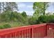 Wood deck area overlooking a fenced backyard with an upward sloping hill of vegetation at 1647 Imperial Ct, Norcross, GA 30093