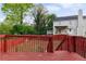 Two-story home with a wood deck overlooking a fenced backyard with some mature trees at 1647 Imperial Ct, Norcross, GA 30093