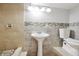 Bathroom featuring neutral tile walls, pedestal sink, and tiled shower at 1647 Imperial Ct, Norcross, GA 30093
