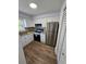 Well-lit kitchen featuring stainless steel appliances, wooden floors, and granite countertops at 173 Amherst Nw Pl, Atlanta, GA 30327