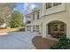 Rear exterior view of home with multiple garage spaces, a covered patio, and brick and stone accents at 3114 Peachtree Ne Dr, Atlanta, GA 30305