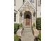 Charming stone entryway with a wooden front door, decorative lighting, and manicured landscaping at 3114 Peachtree Ne Dr, Atlanta, GA 30305