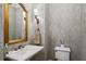 Stylish powder room with designer wallpaper, a pedestal sink, and gold accents at 3114 Peachtree Ne Dr, Atlanta, GA 30305
